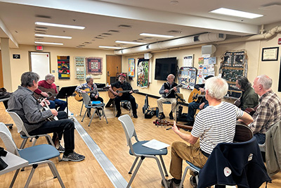 Volunteer leads the weekly acoustic jam session
