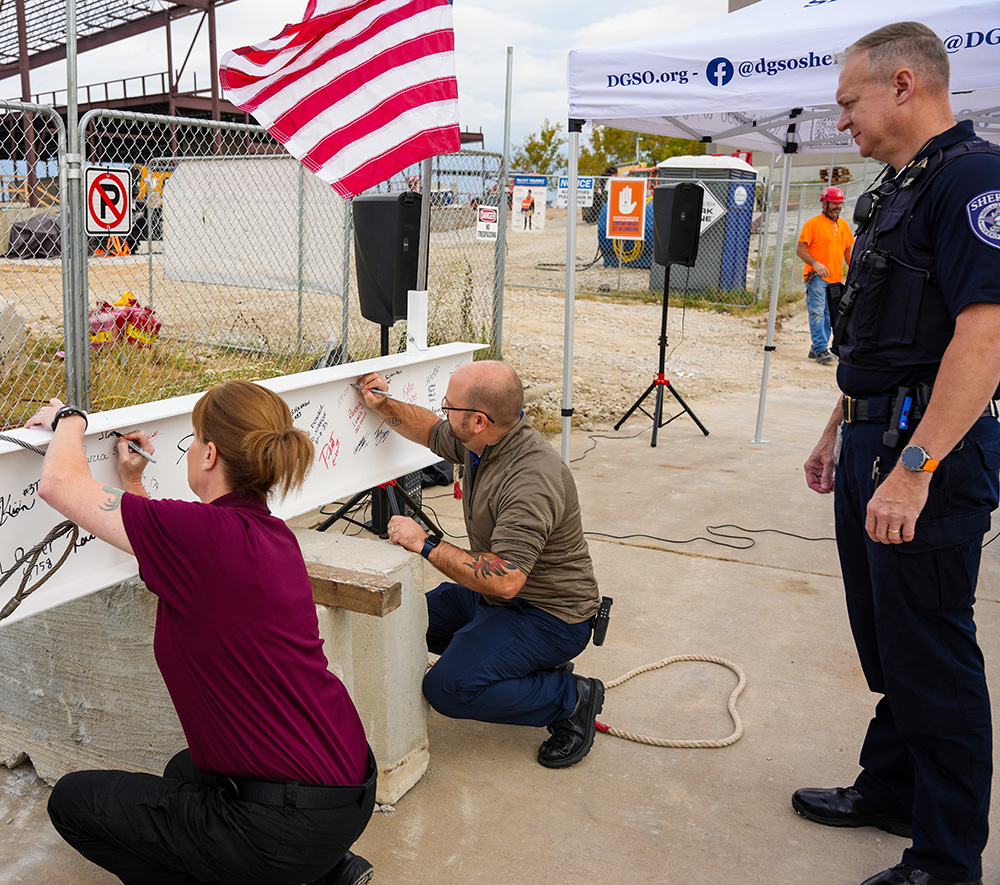 Public safety staff signing steel beam