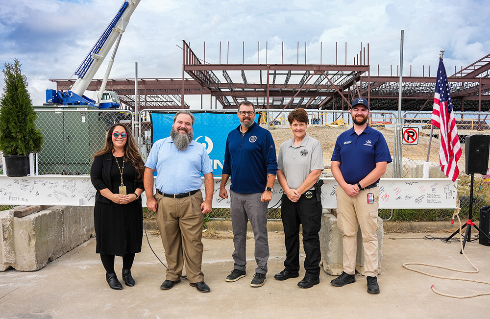 Public safety leaders in front of steel beam and building scaffolding
