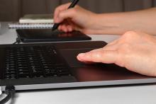Hands working on laptop and tablet device