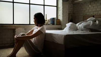 Stock photo - young women sitting thoughtfully by bed