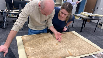 Austin Buhta, of Augustana University, consults an atlas as part of his work.