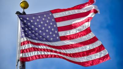 American Flag blowing in wind before a blue sky