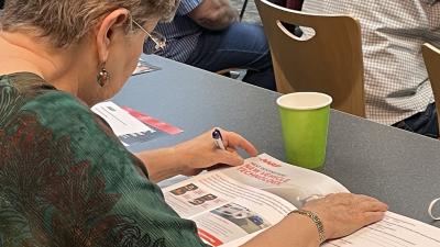 Woman looks over course information in adult class room setting
