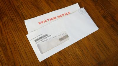 An opened evelope on a table shows an eviction letter inside